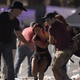 An injured concertgoer is carried at the Route 91 Harvest Country Music Festival in Las Vegas after a gunman opened fire, killing at least 50 people, Oct. 1, 2017. (David Becker/Getty Images)